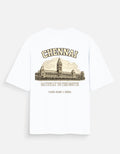 A white short-sleeve t-shirt with a vintage-style graphic print on the front. The graphic features the word 'CHENNAI' in arched tan letters above an illustration of the Chinnaswamy Temple in Chennai, with the text 'GATEWAY TO THE SOUTH' and 'Tamil Nadu, India' printed below.