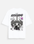 White short-sleeve T-shirt shown flat against a light gray background, featuring a large black and white illustrated graphic of Hyderabad with the word 'HYDERABAD' in bold black letters and smaller black text and doodles.