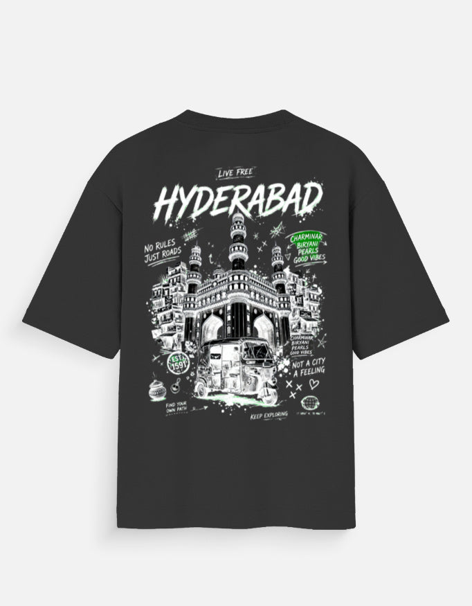 A black short-sleeve t-shirt with a large white and green graphic print on the back, featuring the word 'HYDERABAD' and an illustration of the Fort John building in Hyderabad, India.