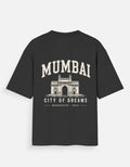 A black short-sleeve t-shirt with a cream-colored graphic print on the back. The graphic features the word 'MUMBAI' in arched block letters above an illustration of the Gateway of India, with 'CITY OF DREAMS' and 'MUMBAI - INDIA' printed below.