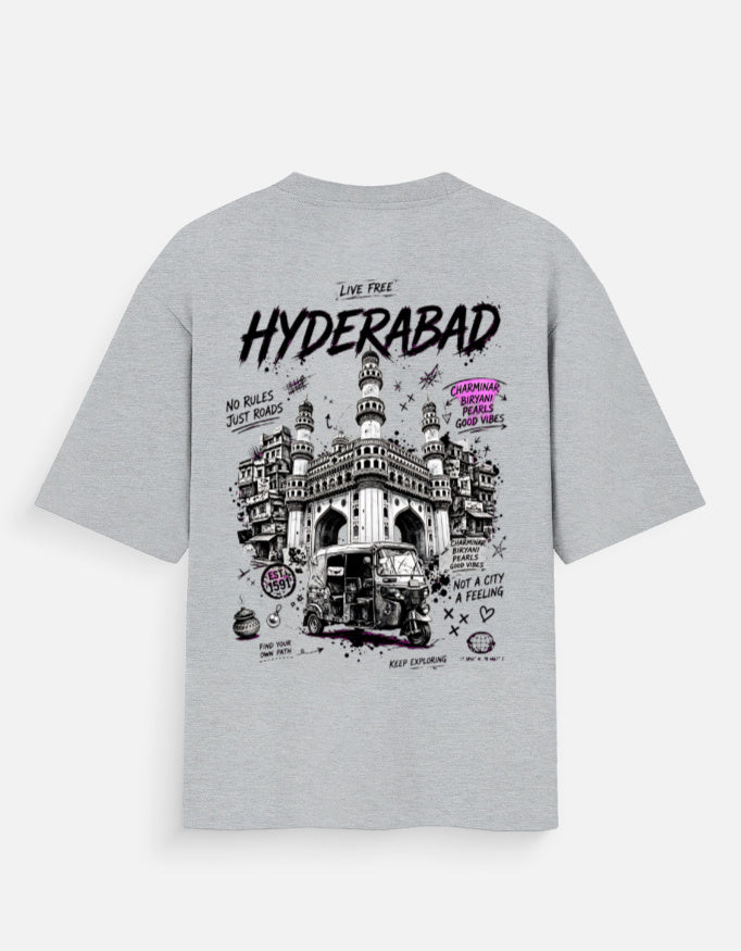 A light gray heather short-sleeve t-shirt shown from the back, featuring a large graphic print of the Charminar in Hyderabad with the text 'HYDERABAD' and 'LIFE FREE HYDERABAD'.