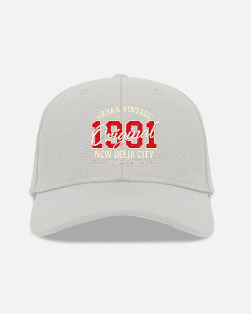 A light gray baseball cap with a red and cream graphic on the front reading '1921' and 'Urban Vintage Original New Delhi City'.