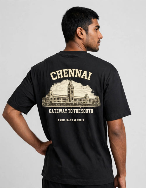 A man wearing a black t-shirt, shown from the back. The shirt features a large cream-colored graphic print of the Chennai Municipal Council building with the text 'CHENNAI GATEWAY TO THE SOUTH' and 'TAMIL NADU INDIA'.